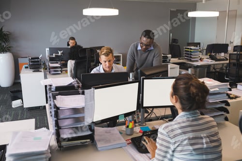 Preview: Business colleagues working on computers at desk