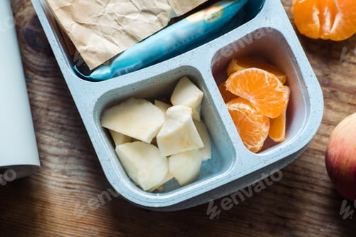 Preview: schoolboy lunch box with thermos on wooden background.apple,tangerine,sandwich in lunchbox