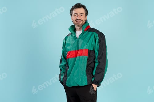 Preview: Smiling man wearing retro 90s style jacket posing on blue background