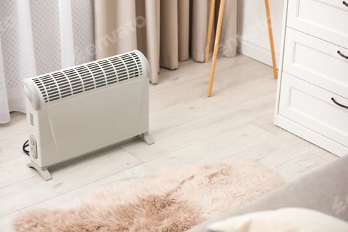 Preview: Modern electric heater on floor at home