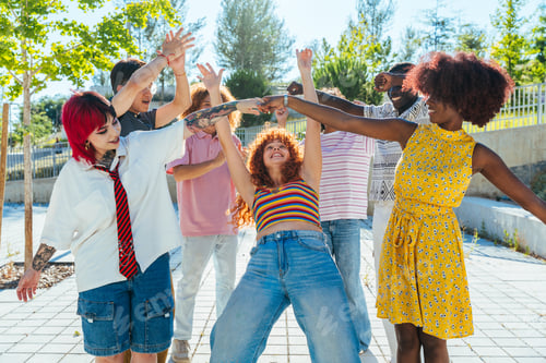Preview: Multiethnic group of young friends meeting and having fun outdoors