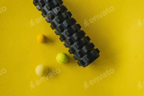 Preview: Equipment for MFR. Balls and roll on a yellow mat for yoga or fitness. Self-massage tools