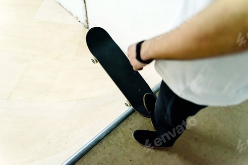 Preview: Young man performing acrobatics with a skate indoor.