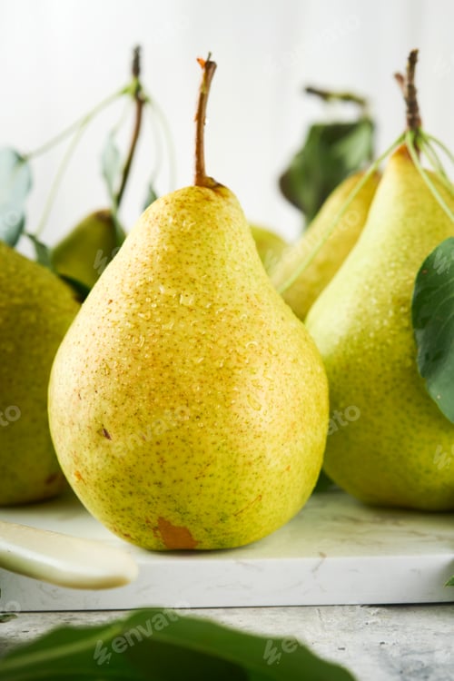 Preview: Pears. Fresh sweet organic pears with leaves on stand or plate on old stone tile background. Frame o