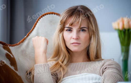 Preview: Angry woman sitting on armchair at home looking at camera, negative emotions