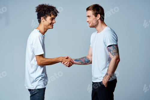 Preview: two friends hold hands in white t-shirts isolated background