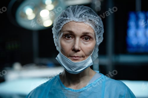 Preview: Portrait of Woman Surgeon in Dark Operating Room