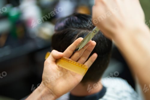 Preview: Barber skillfully trims hair using scissors and comb during an appointment