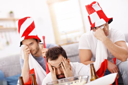 Preview: Happy male friends cheering and watching sports on tv