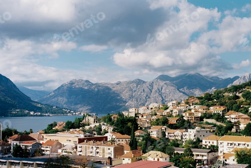 Preview: Houses of the port of Kotor among green trees at the foot of the mountains. Montenegro