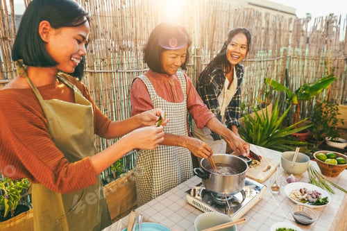 Preview: Asian family cooking thai food together at home patio outdoor