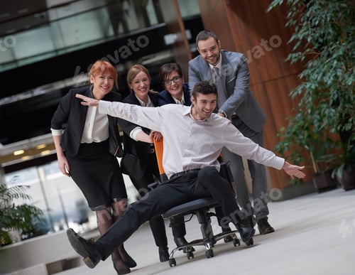 Preview: Business People Group At Modern Office Indoors Have Fun And Push Office Chair On Corridor