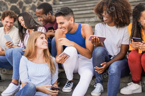 Preview: Group of young multiracial people having fun in the city with mobile phone