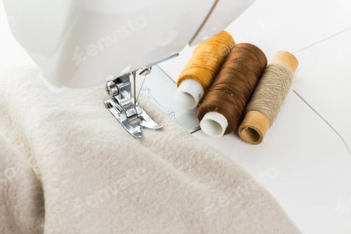 Preview: Sewing machine with spools of thread on fabric creates handmade textile project