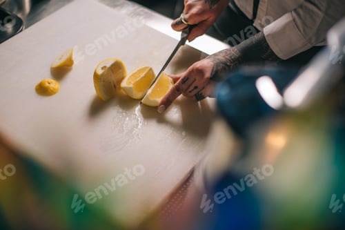 Preview: cropped image of girl cutting lemon for drinks
