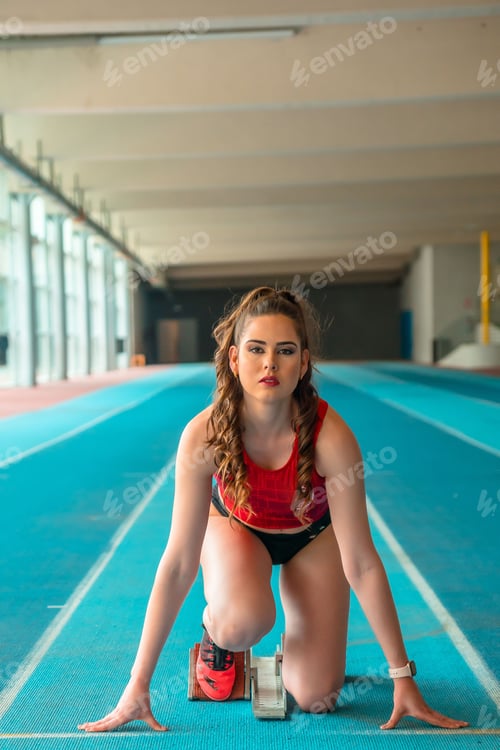 Preview: Vertical shot of a sprinter woman preparing for the start of the race in training