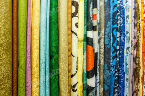 Preview: wide selection of different color textile silk fabrics clothes lay in row in drapery store
