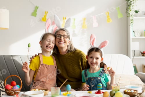 Preview: Grandmother and Granddaughters Painting Easter Eggs Together at Home