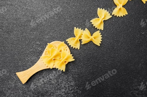 Preview: Creative arrangement of bowtie pasta on a dark kitchen surface