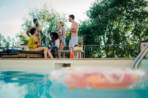 Preview: Friends enjoying drinks and conversation by the pool during summer vacation