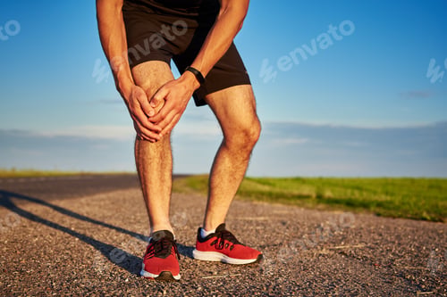 Preview: Male runner hold his knee. Leg injury while running