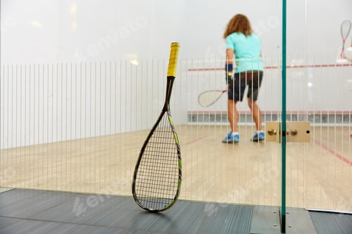 Preview: Squash racket leaned on net and sportspeople playing