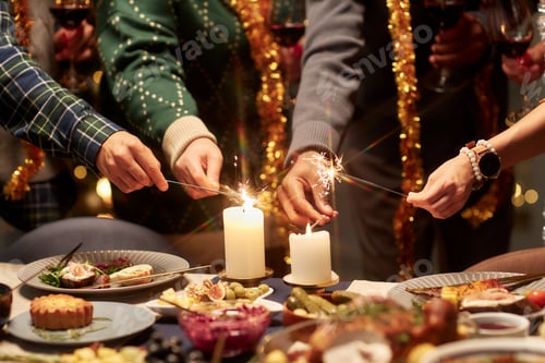 Preview: Hands of Multiethnic People Lighting Sparklers from Candlelight during Festive Dinner
