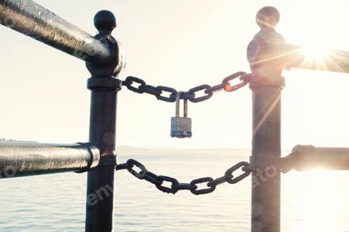 Preview: Block chain technology, a lock on a chain at sunset with sunburst.