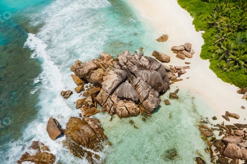 Preview: Seychelles La Digue Island. Aerial view of ocean waves and huge granite rocks on the tropical beach