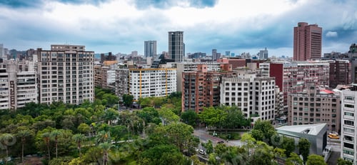 Preview: A panoramic view of Taipei city skyline showcasing buildings and greenery on a cloudy day