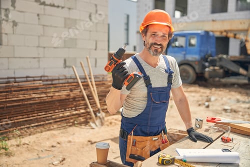 Preview: Smiling man holding a screw gun in his hand