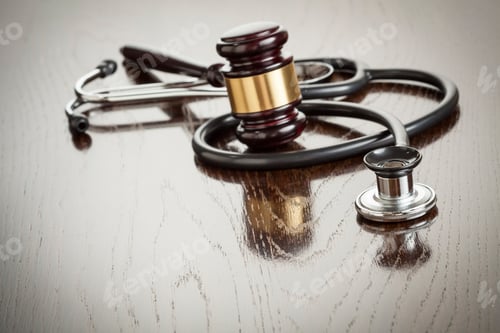 Preview: Gavel and Stethoscope on Reflective Wooden Table.