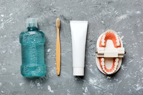 Preview: Mouthwash and other oral hygiene products on colored table top view with copy space