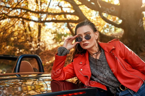 Preview: Close-up of woman in red near cabriolet. She wearing sunglasses