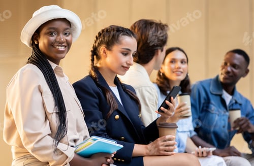 Preview: Friends with disposable coffee cup talking in college park