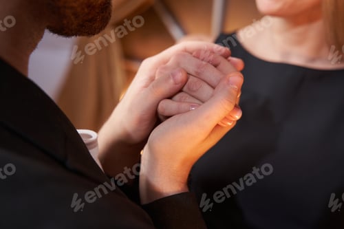 Preview: Man tenderly taking woman hand into his