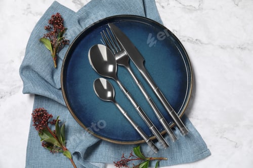 Preview: Stylish setting with elegant cutlery on white marble table, top view