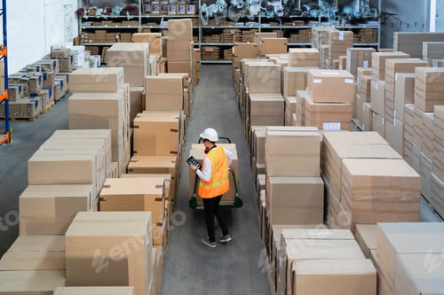 Preview: Logistic warehouse worker delivering boxes on a trolley