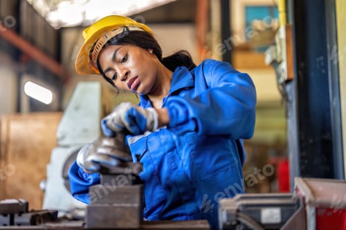 Preview: Woman worker in uniform operating machine at factory concentrate on fabrication job on lathe