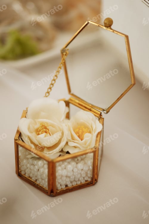 Preview: White fresia flower and gift box with diamond ring on color background, top view