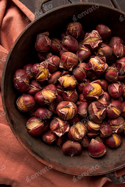 Preview: Roasted chestnuts, in an iron pan, wooden table, top view, no people, rustic style,