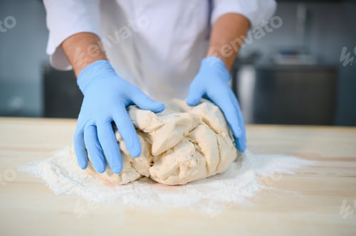 Preview: Baker man kneading dough and bakery ingredients for bread cooking on table. Bakery concept