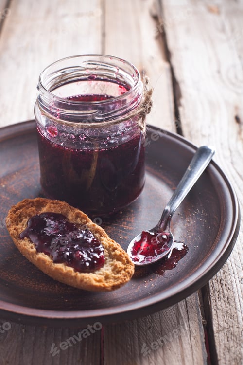 Preview: black currant jam in glass jar and crackers