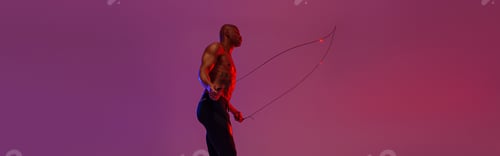 Preview: Man skipping with jump rope on studio background. Strength and motivation. Best cardio workout