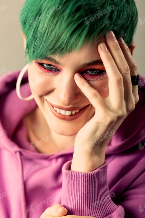 Preview: Pleasurable Mood. Portrait Of A Cheerful Short Haired Woman Smiling While Touching Her Face