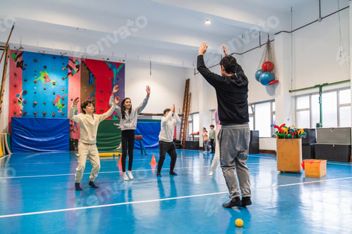 Preview: Group of children doing gymnastics exercises with their coach in the gym
