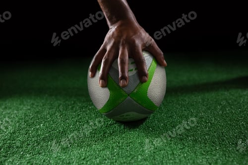 Preview: Cropped hand of person on rugby ball