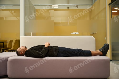 Preview: Calm man lying on sofa and looking up