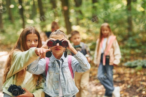 Preview: Front view of kids that is in green forest at summer daytime together