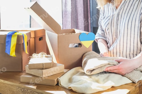 Preview: Donations Ukraine, volunteering, charity, war refugees. Girl collects clothes charity